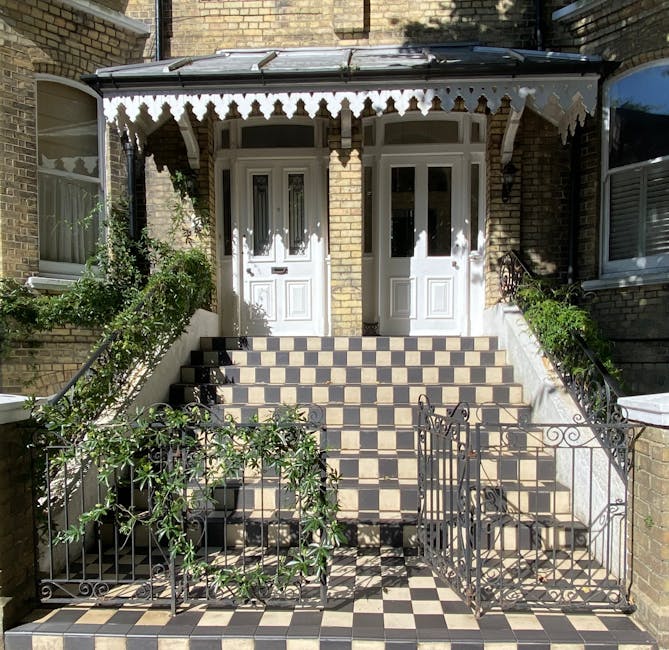 A front garden stairway leading up to a pair of white front doors with decorative paneling and glass inserts, situated within a brick building. The staircase features a checkered pattern of black and 